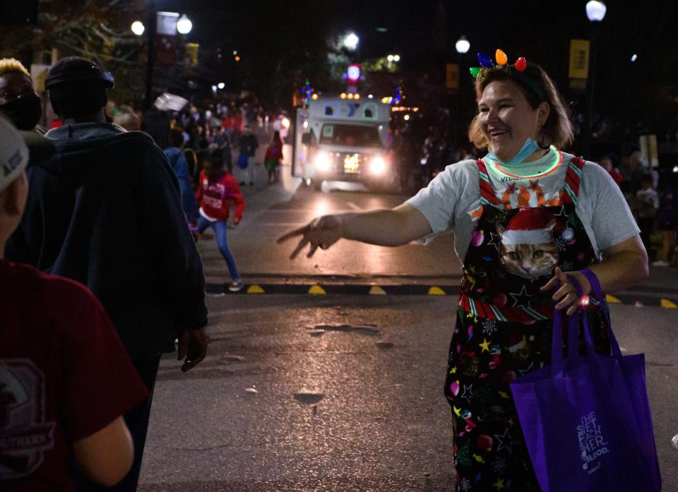 A a person passes out candy during the annual Hattiesburg, Miss., Christmas parade on Thursday, December 2, 2021.