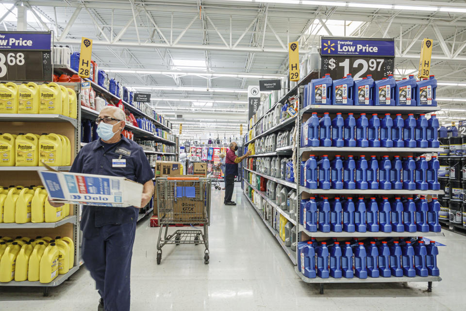 Walmart discount department store employees stocking shelves with engine oil in Miami, Florida. (Photo by: Jeffrey Greenberg/Universal Images Group via Getty Images)
