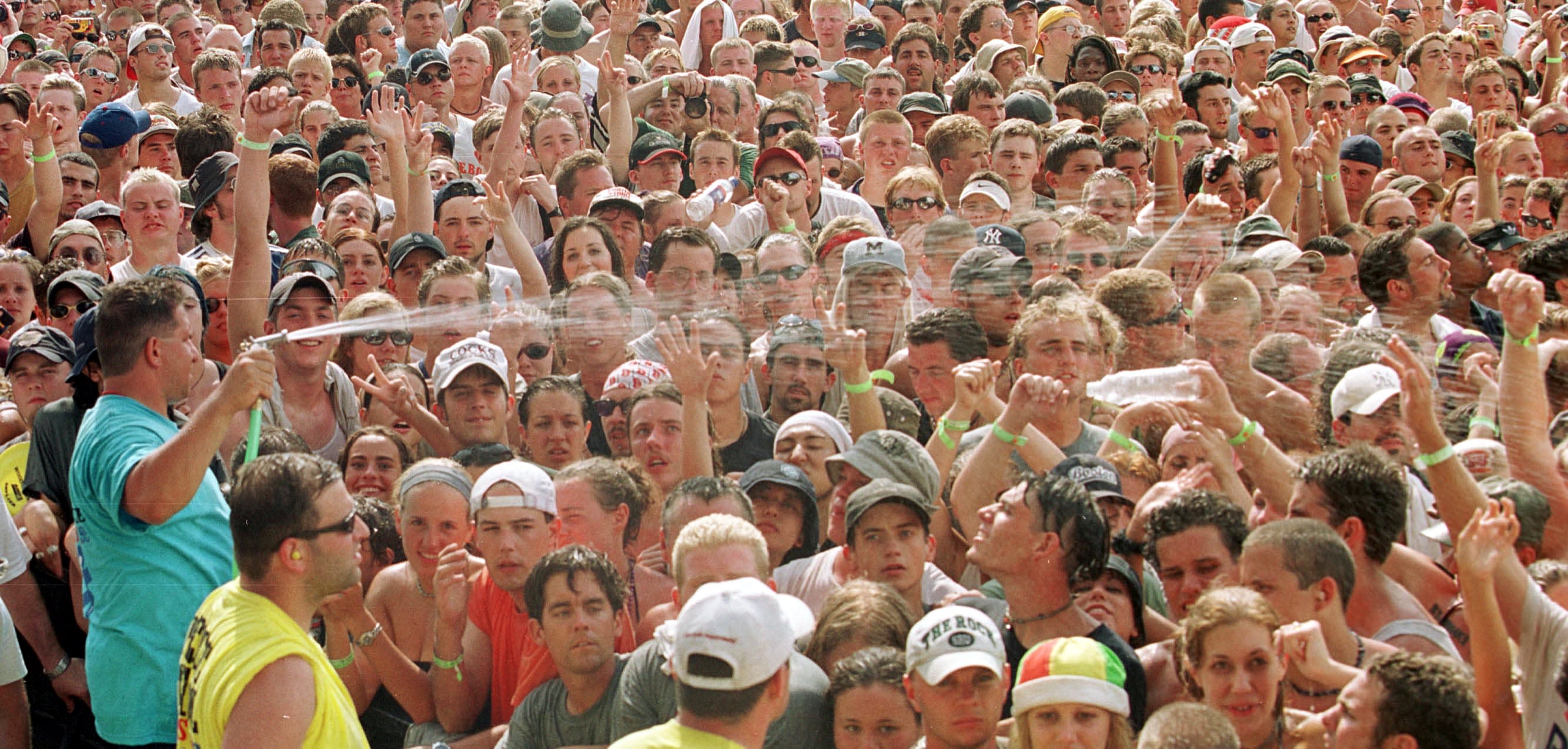 A large crowd is sprayed with water.