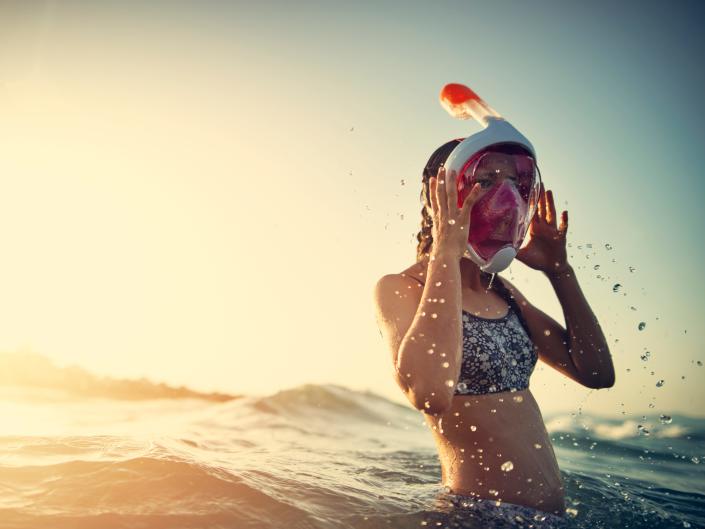 Una niña con una máscara de snorkel de cara completa