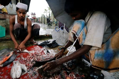 Muslim vendors sell fish at a market of Maungdaw