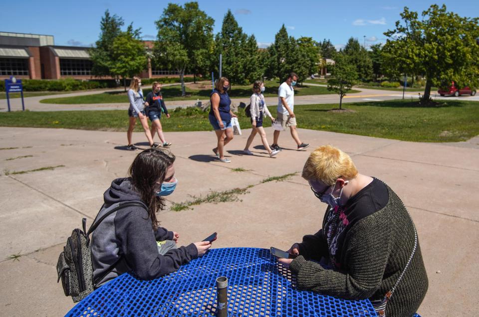 Lake Superior State University freshman Taylor Owrutsky, left, talks with junior Katherine Davis about theater club as students and family walk around campus during a move-in day for students at Lake Superior State University in Sault Ste. Marie. "I'm just cautious so I have a bunch of masks. I'll wear the masks but if we ever get free from COVID I'll definitely be a bit more scot-free," Owrutsky said.