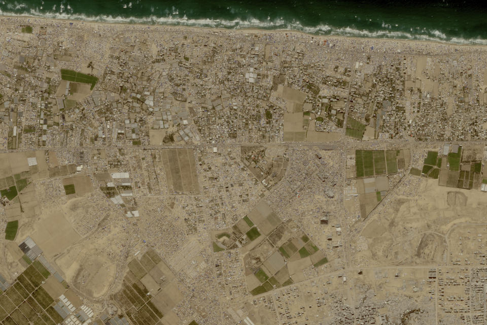 This image provided by Planet Labs PBC shows tent camps line the beach and fill empty lots outside the central Gaza city of Khan Younis, Friday, May 24, 2024, housing Palestinians who fled Israel's offensive in Rafah the past three weeks. (Planet Labs PBC via AP)