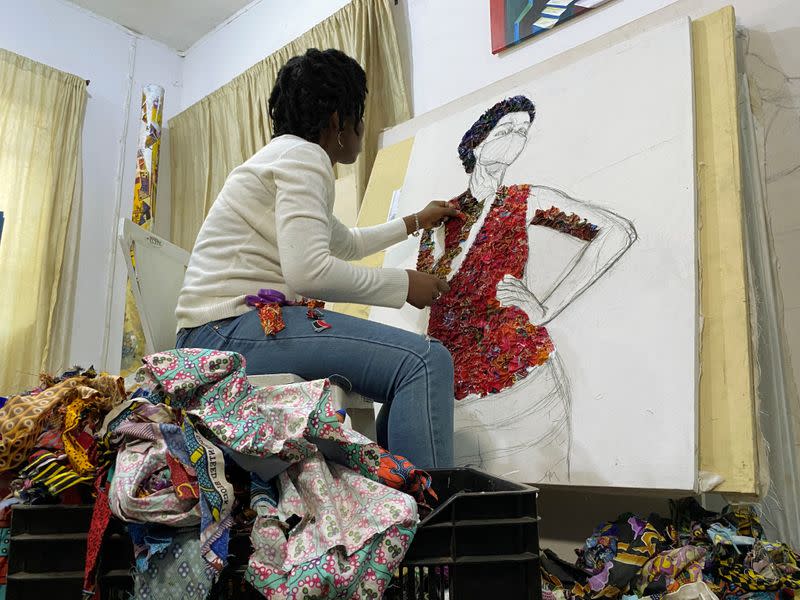 Marcellina Akpojotor creates an art piece of a woman with a face mask using waste Ankara fabric in Lagos