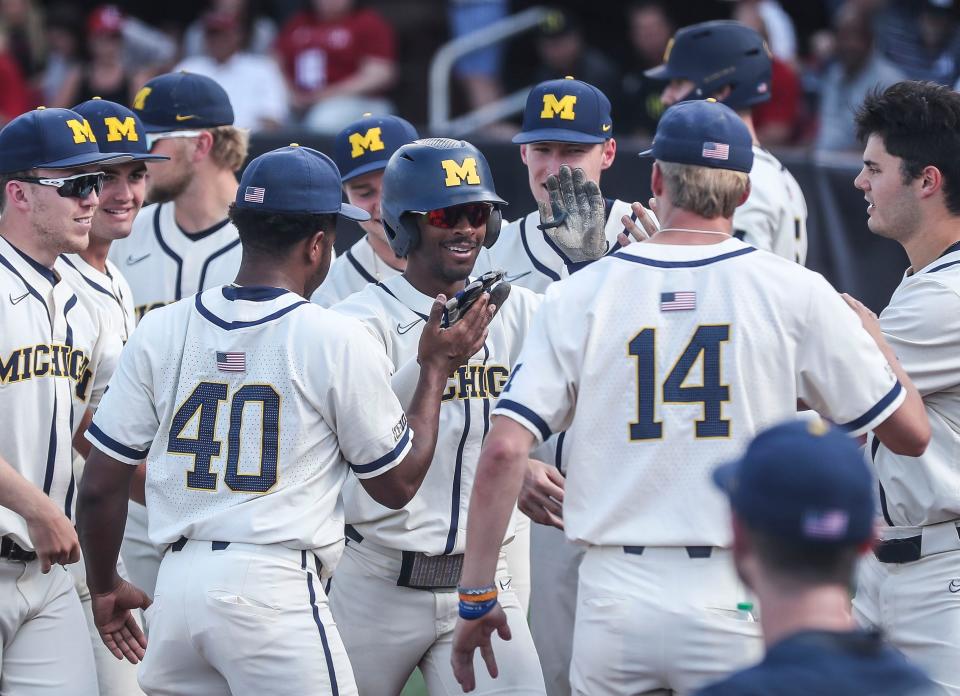 Michigan's Clark Elliott gets congratulated after hitting a two-run homer against Louisville. The Cards fell 7-3 to the Wolverines in the 2022 NCAA Regional Saturday. June 4, 2022