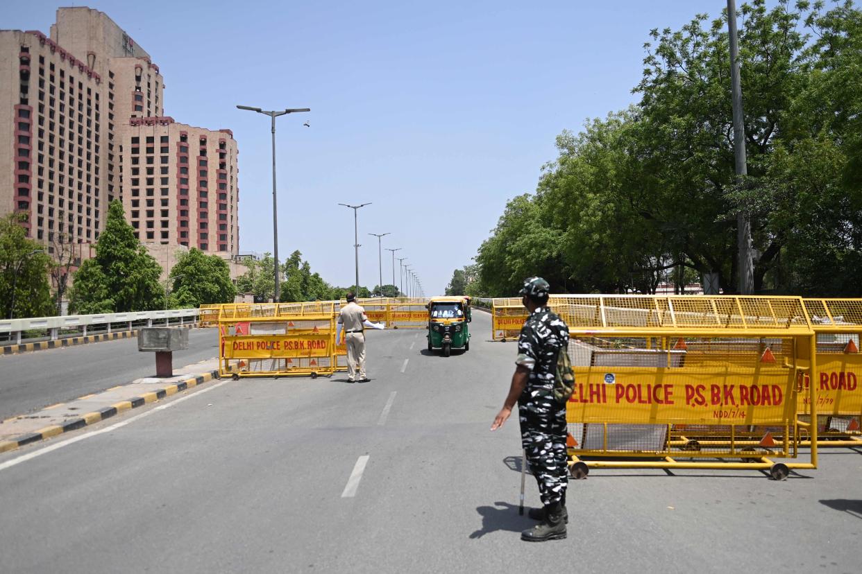 <p>Police personnel at a checkpoint during a weekend lockdown imposed by Delhi on 18 April, 2021.</p> (AFP via Getty Images)