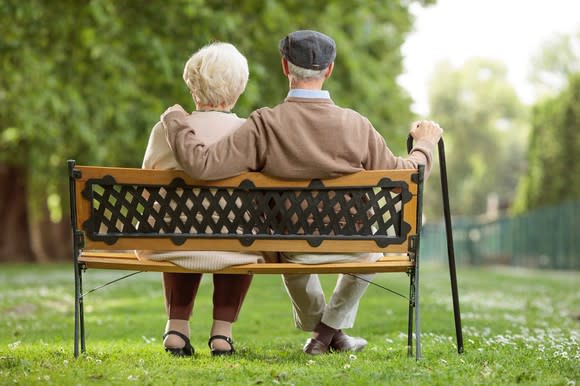 Older couple sitting on a park bench.