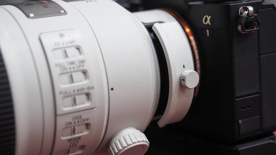 Sony FE 300mm f/2.8 GM OSS lens on a red table with grey curtains