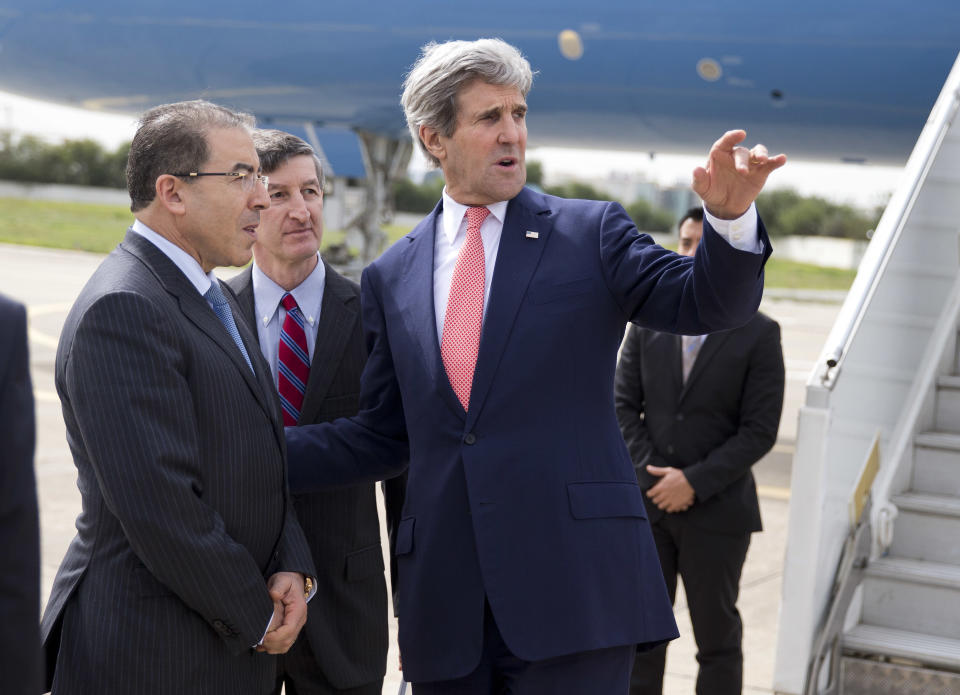Secretary of State John Kerry, right, talks with Tunisian Foreign Minister Mongi Hamdi, left, and ambassador Jake Walles after arriving at El Aouina Air Base Tuesday, Feb. 18, 2014, in Tunis. Kerry is in Tunisia to offer continued American assistance for the North African nation where uprisings that toppled authoritarian leaders around the Arab world ignited in 2011. (AP Photo/ Evan Vucci, Pool)