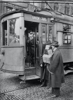 <span class="caption">Precautions taken during the 1918 flu pandemic would not allow anyone to ride street cars without a mask. Here, a conductor bars an unmasked passenger from boarding.</span> <span class="attribution"><a class="link " href="https://www.gettyimages.com/detail/news-photo/precautions-taken-during-spanish-influenza-epidemic-would-news-photo/1223011380" rel="nofollow noopener" target="_blank" data-ylk="slk:Universal History Archive/Getty Images;elm:context_link;itc:0;sec:content-canvas">Universal History Archive/Getty Images</a></span>