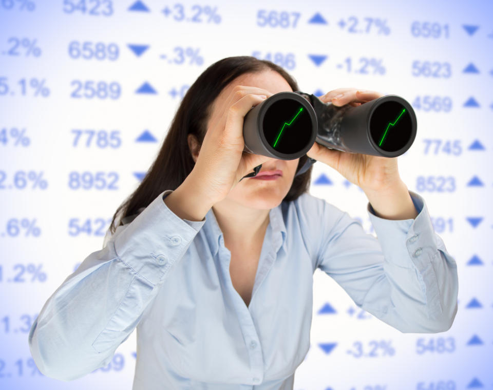 Person looking through binoculars with upward sloping charts on the lenses.