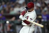 Arizona Diamondbacks' Joc Pederson starts his swing for a double against the Colorado Rockies during the first inning of a baseball game Friday, March 29, 2024, in Phoenix. (AP Photo/Ross D. Franklin)