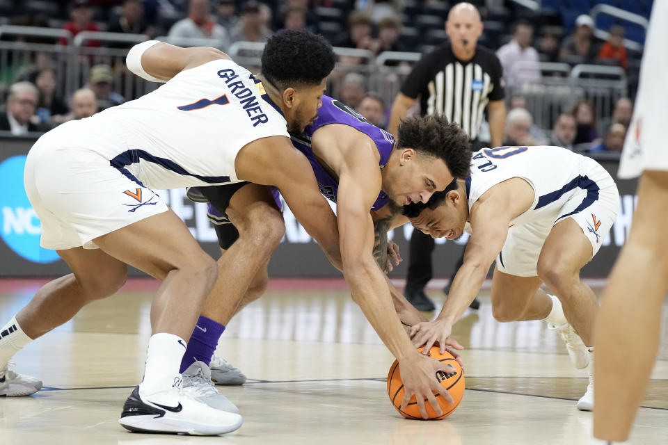 Furman forward Jalen Slawson (20) battles with Virginia forward Jayden Gardner (1) and guard Kihei Clark (0) for a loose ball during the first half of a first-round college basketball game in the NCAA Tournament Thursday, March 16, 2023, in Orlando, Fla. (AP Photo/Chris O'Meara)