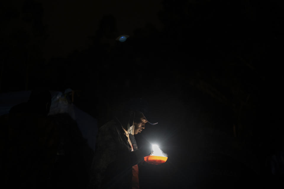 A migrant from Senegal has dinner in Las Raices camp in San Cristobal de la Laguna, in the Canary Island of Tenerife, Spain, Wednesday, March 17, 2021. Several thousand migrants have arrived on the Spanish archipelago in the first months of 2021. Due to the terrible living conditions and the poor quality of food and water at the Las Raices camp, some migrants have decided to leave the camp and sleep in shacks in a nearby forest instead. (AP Photo/Joan Mateu)