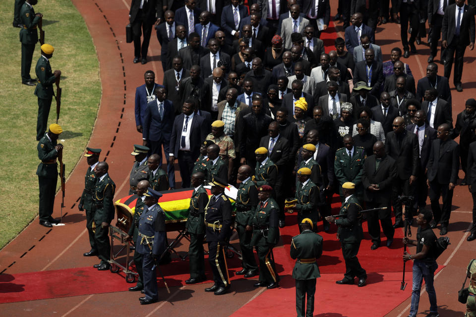 Former Zimbabwean President Robert Mugabe's coffin arrives for a state funeral for at the National Sports Stadium in Harare, Saturday, Sept. 14, 2019. African heads of state and envoys are gathering to attend a state funeral for Mugabe, whose burial has been delayed for at least a month until a special mausoleum can be built for his remains. (AP Photo/Themba Hadebe)
