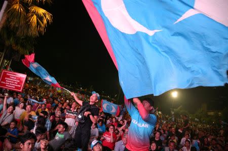 Supporters of Mahathir Mohamad, former Malaysian prime minister and opposition candidate for Pakatan Harapan (Alliance of Hope), celebrate outside the hotel, where Mahathir Mohamad held news conference, in Petaling Jaya, Malaysia, May 10, 2018. REUTERS/Athit Perawongmetha