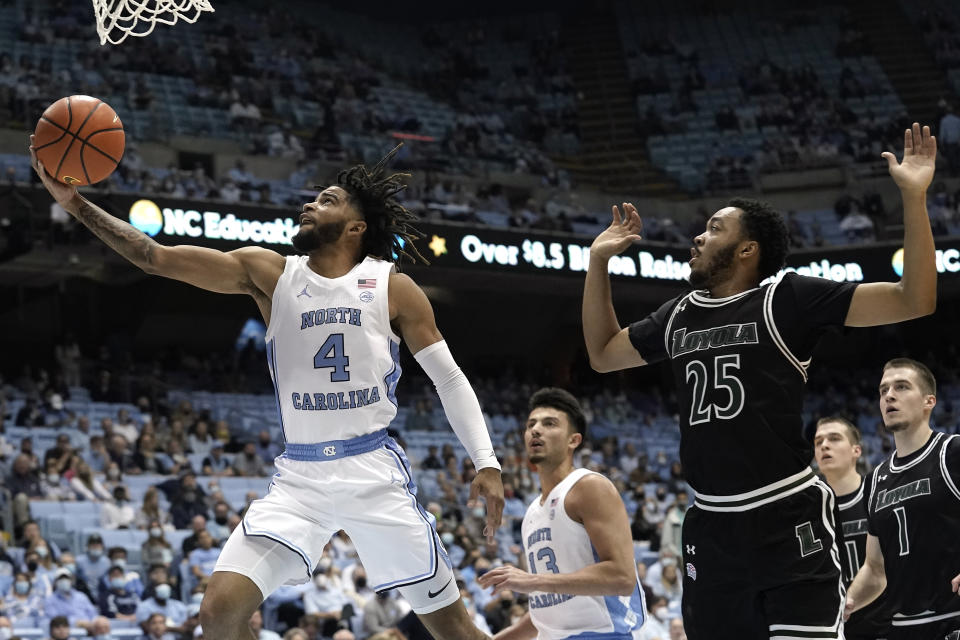 North Carolina guard R.J. Davis (4) drives to the basket while Loyola Maryland guard Kenny Jones (25) defends during the first half of an NCAA college basketball game in Chapel Hill, N.C., Tuesday, Nov. 9, 2021. (AP Photo/Gerry Broome)