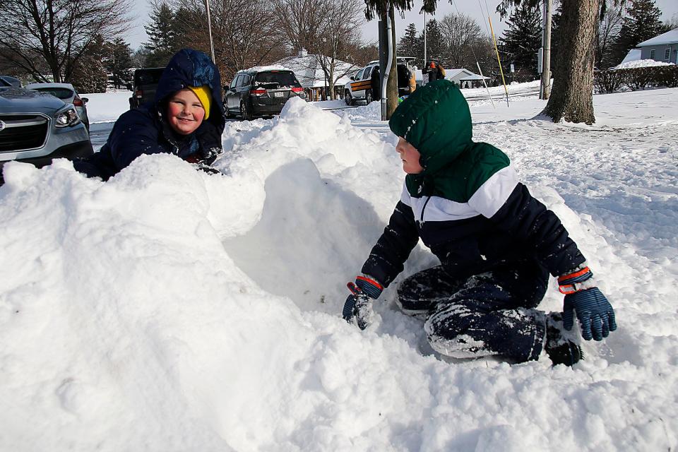 Caleb and Conner Archer dig a tunnel in a pile of snow at the Ashland Golf Club on Monday, Jan. 17, 2022. TOM E. PUSKAR/TIMES-GAZETTE.COM