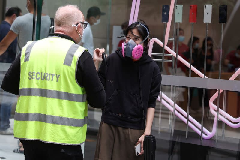 A person wearing a protective respirator enters a queue in Sydney
