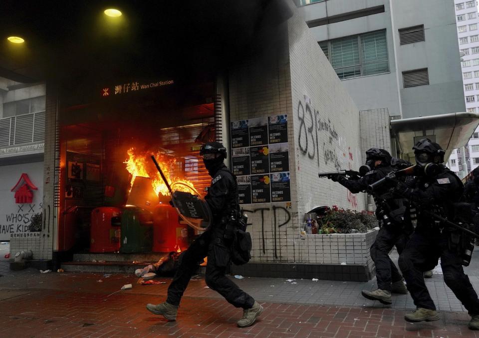 Riot police arrive after protestors vandalize in Hong Kong, Sunday, Sept. 29, 2019. Riot police fired tear gas Sunday after a large crowd of protesters at a Hong Kong shopping district ignored warnings to disperse in a second straight day of clashes, sparking fears of more violence ahead of China's National Day. (AP Photo/Vincent Yu)
