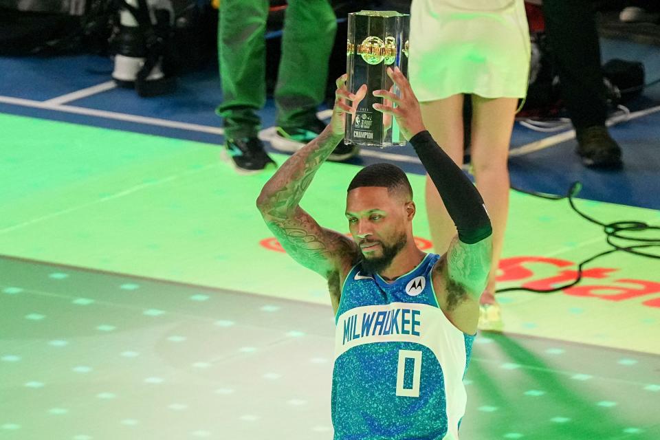 Milwaukee Bucks guard Damian Lilard (0) hoists his trophy after winning the three-point contest Saturday, Feb. 17, 2024, during NBA All-Star Saturday Night at Lucas Oil Stadium in downtown Indianapolis.