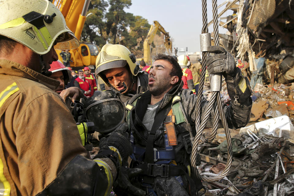 Firefighters help their colleague during debris