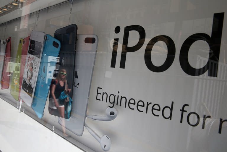 A pedestrian is reflected in a window as she walks by an Apple Store on April 23, 2013 in San Francisco, California. Apple announced that its board of directors has endorsed a plan to more than double to $100 billion the amount of its stock it will buy back in the coming three years