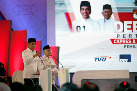 Indonesia's presidential candidate Joko Widodo speaks next to his running mate Ma'ruf Amin, during a televised debate with his opponents Prabowo Subianto and Sandiaga Uno (not pictured) in Jakarta, January 17, 2019. REUTERS/Willy Kurniawan