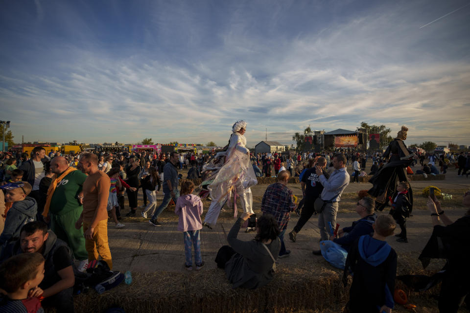 Entertainers on stilts walks among participants at the West Side Hallo Fest, a Halloween festival in Bucharest, Romania, Saturday, Oct. 28, 2023. Tens of thousands streamed last weekend to Bucharest's Angels' Island peninsula for what was the biggest Halloween festival in the Eastern European nation since the fall of Communism. (AP Photo/Andreea Alexandru)