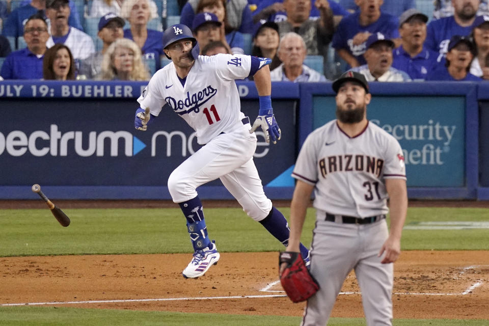 Los Angeles Dodgers' AJ Pollock, left, runs to first after hitting a solo home run as Arizona Diamondbacks starting pitcher Caleb Smith watches during the first inning of a baseball game Saturday, July 10, 2021, in Los Angeles. (AP Photo/Mark J. Terrill)