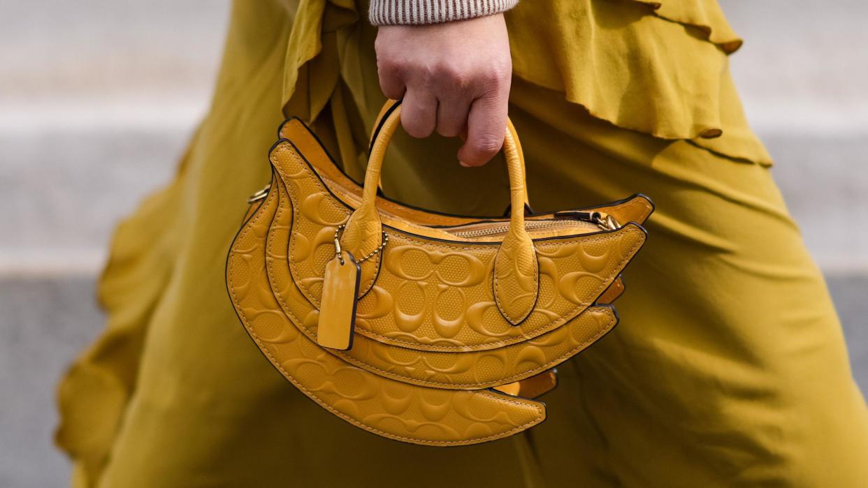 A yellow banana shaped leather bag with embossed logos from Coach.