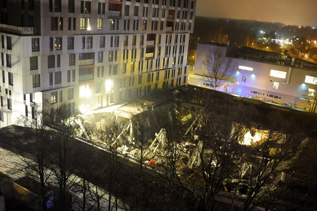 A late Thursday, Nov. 21, 2013 view of the collapsed Maxima supermarket in Riga, Latvia. At least 32 people died, including three firefighters, after an enormous section of roof collapsed at a Latvian supermarket in the country's capital, emergency medical officials said Friday. The reason for the collapse during shopping rush-hour Thursday was still not known but rescue and police officials said that possible theories include building's design flaws and poor construction work. (AP Photo/ Maris Morkans)