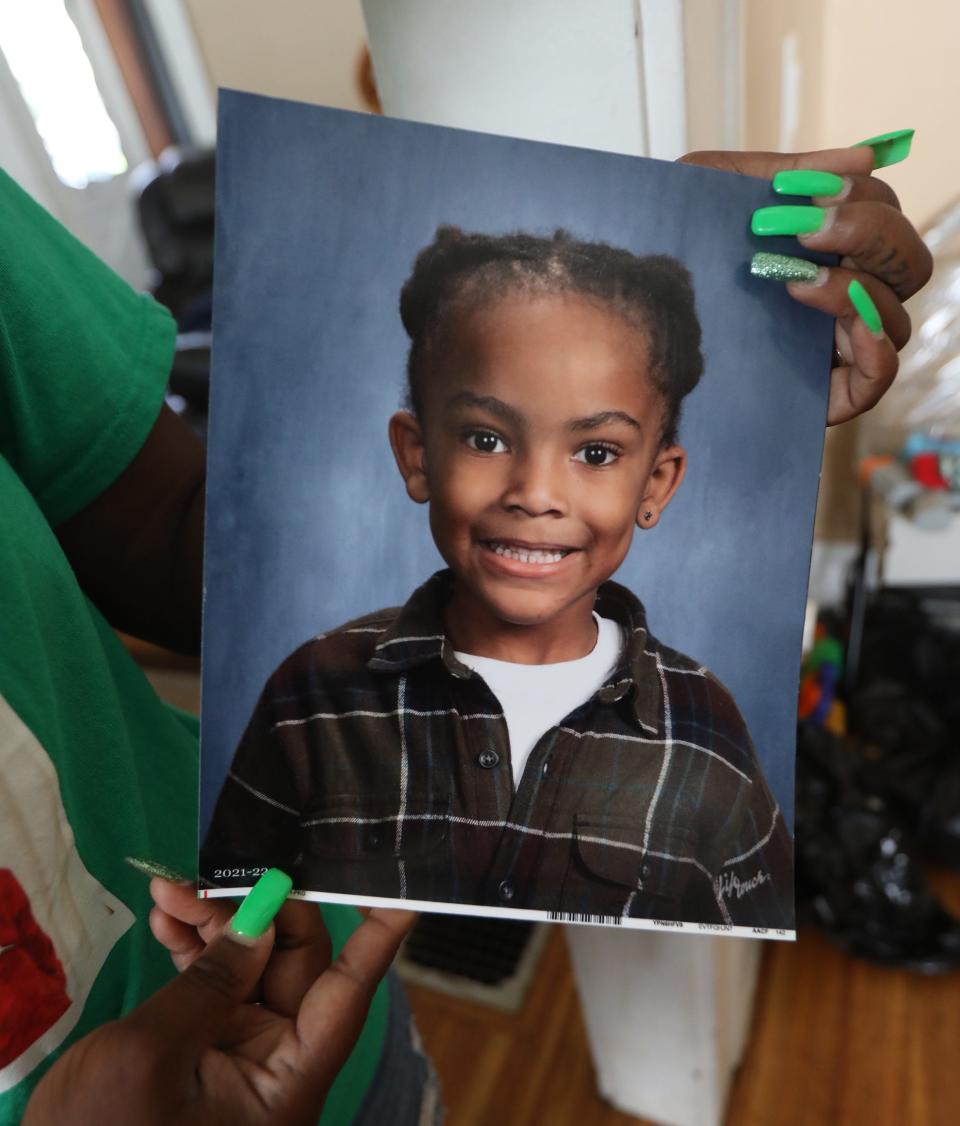 Farasa Brown holds up a 2021-22 school photo of her son, Ryan Grantham Jr., known as "RJ" or “Bear." The child was fatally struck by a truck in June on Thurston Road. Brown wears green and has green fingernail polish because that was her son's favorite color.