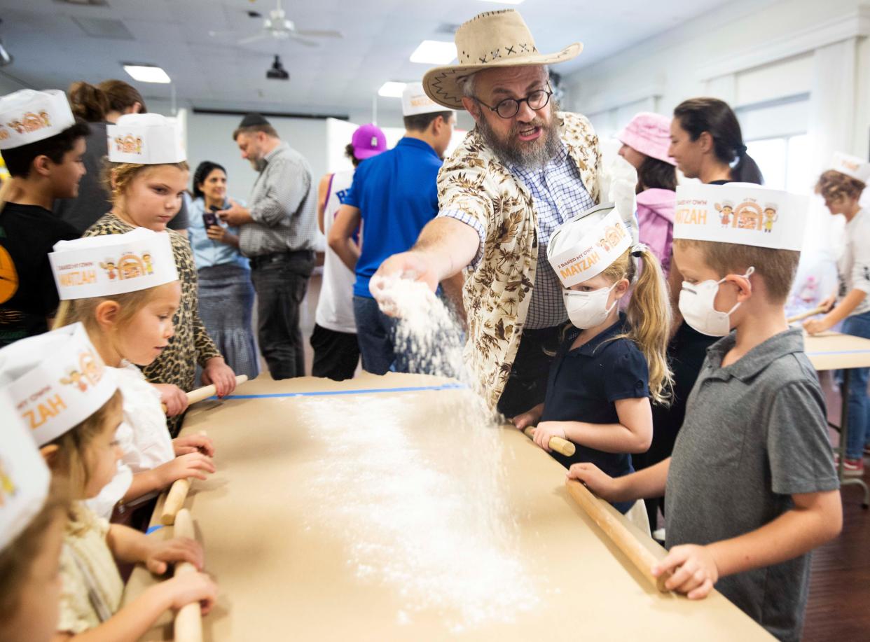 Rabbi Aron Rabin places flour on a table for the Family Matzah Bake on Wednesday, April 6, 2022, at the Chabad of Naples in Naples, Fla.