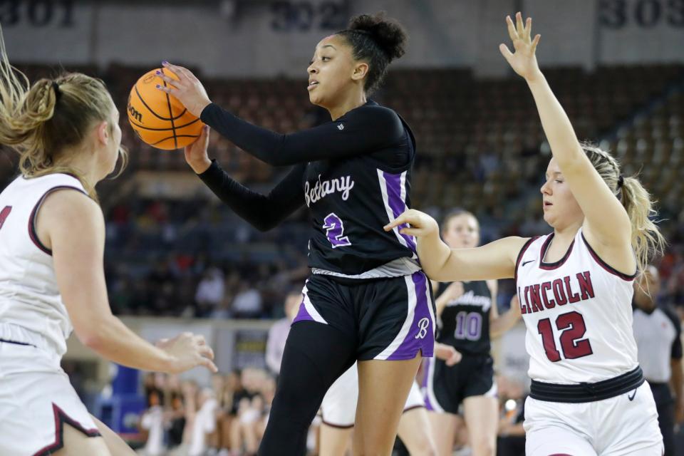 Bethany's Zya Vann passes the ball from beside Lincoln Christian's Payton Rea (12) during the Class 4A girls state basketball championship between Bethany and Lincoln Christian at the State Fair Arena in Oklahoma City, Saturday, March 11, 2023.