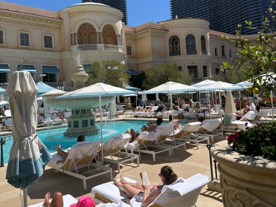 COMO rooftop pool deck filled with umbrellas, lounge chairs, people