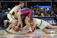 Boston Celtics guard Payton Pritchard, left, and Boston Celtics forward Blake Griffin reach in on Detroit Pistons forward Bojan Bogdanovic during the first half of an NBA basketball game, Monday, Feb. 6, 2023, in Detroit. (AP Photo/Carlos Osorio)