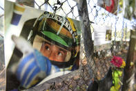 FILE - Pictures of late Brazilian race car driver Ayrton Senna hangs on the the corner where he was died, during the third practice session ahead of Sunday's Emilia Romagna Formula One Grand Prix, at the Enzo and Dino Ferrari racetrack, in Imola, Italy, Saturday, Oct. 31, 2020. The 30th anniversary of Ayrton Senna’s death is commemorated on Wednesday, May 1, 2024, with a memorial on the Imola track where he crashed during the 1994 San Marino Grand Prix. (Jennifer Lorenzini, Pool via AP, File)