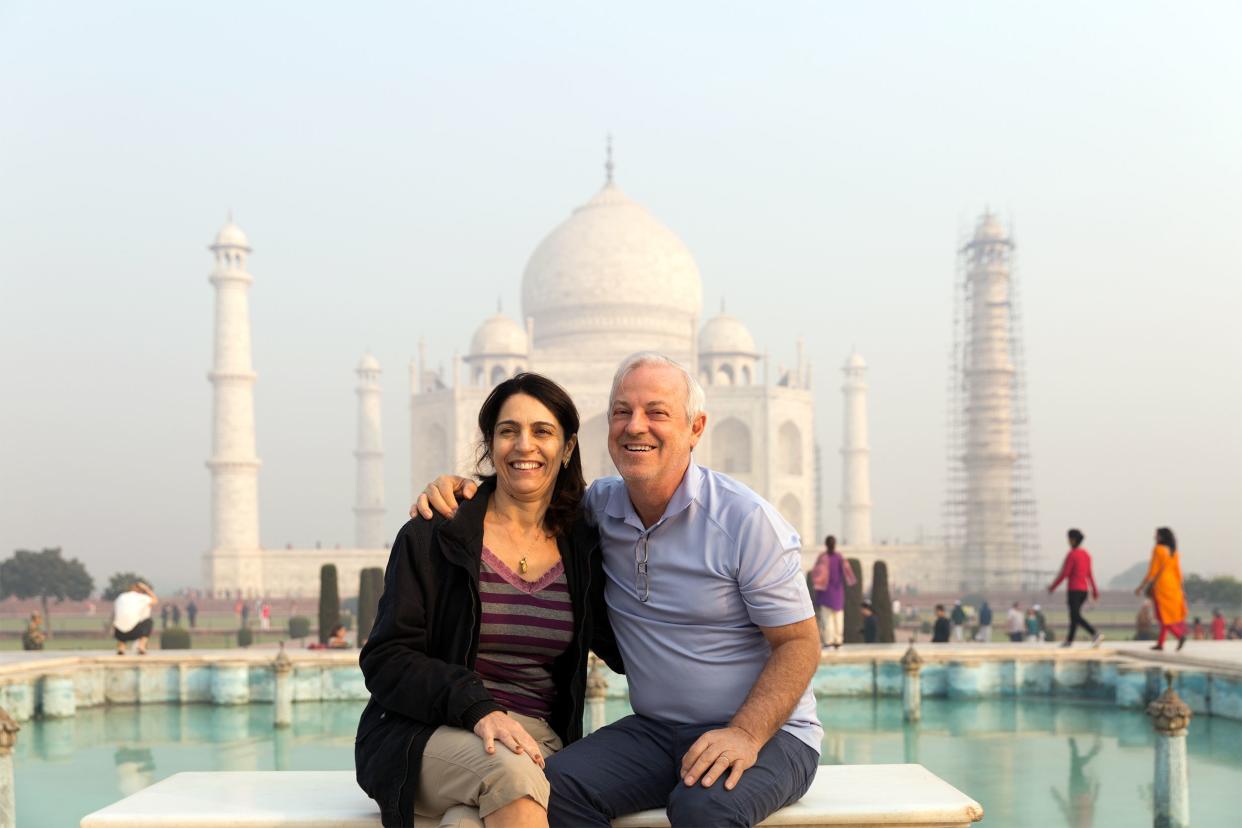 Senior couple taking a picture in front of the Taj Mahal