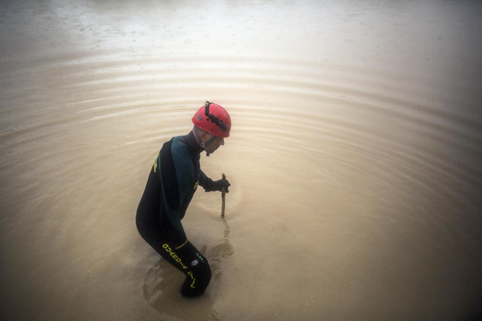 A member of the Spanish civil guard checks a flooded area in the village of Campillos, Spain, where heavy rain and floods have caused severe damage and the death of a firefighter according to Spanish authorities, on Sunday, Oct. 21 2018. Emergency services for the southern region of Andalusia say that the firefighter went missing when his truck overturned on a flooded road during heavy rains that fell through the night, and his body was found after a search Sunday morning. (AP Photo/Javier Fergo)