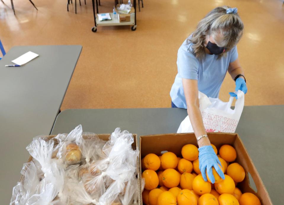 Volunteer Donna Champeau helps prepare to-go meals for the Loaves and Fishes meal program last year in Appleton. This year's Stock the Shelves campaign, a partnership between USA TODAY NETWORK-Wisconsin and Feeding America Eastern Wisconsin, runs from Oct. 1 to 31. To donate online, visit feedingamericawi.org/stocktheshelvesdonate.