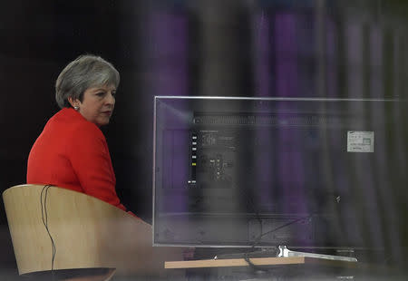 Britain's Prime Minister Theresa May is seen through a window as she is interviewed on the BBC's Andrew Marr Show during the Conservative Party Conference in Birmingham, Britain September 30, 2018. REUTERS/Toby Melville