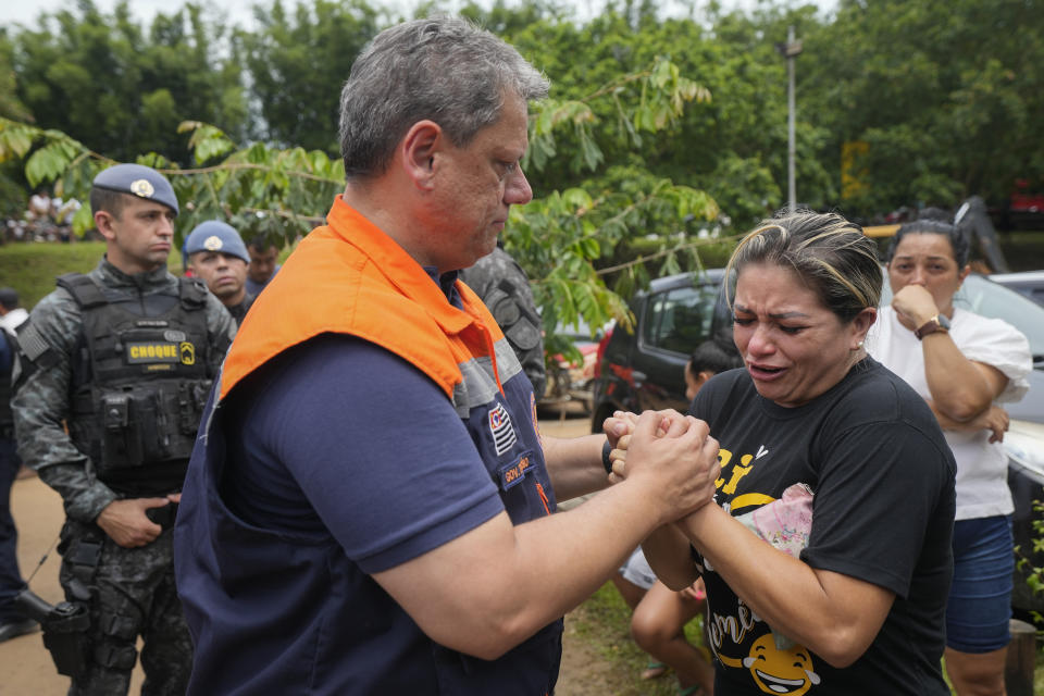 Sao Paulo Governor Tarcisio de Freitas comforts Josimeire Almeida who lost friends in deadly landslides triggered by heavy rains near Barra do Sahi beach in the coastal city of Sao Sebastiao, Brazil, Wednesday, Feb. 22, 2023. (AP Photo/Andre Penner)