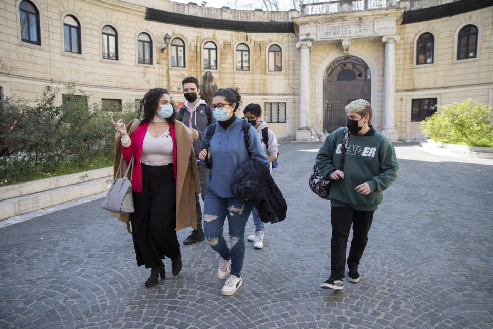 Matteo Coccimiglio, right, leaves the Ripetta art school in Rome, Wednesday, March 24, 2021. Matteo is an 18-year-old student who identifies as a man and is in the process of changing his legal gender from female to male. The Ripetta school of art in Rome - where he studies - recently joined a handful of high schools in Italy that give transgender students the right to be known by a name other than the one they were given at birth. The initiative is meant to create an environment where transgender students feel secure and reflects a growing awareness in Italy of gender dysphoria among teenagers and children. (AP Photo/Alessandra Tarantino)