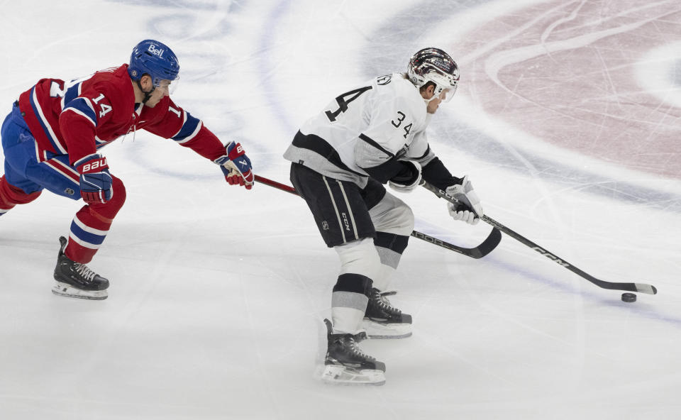 Montreal Canadiens' Nick Suzuki (14) chases Los Angeles Kings' Arthur Kaliyev (34) during the first period of an NHL hockey game Thursday, Dec. 7, 2023, in Montreal. (Christinne Muschi/The Canadian Press via AP)