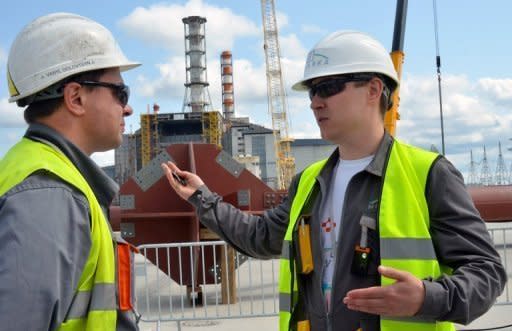 Builders speak to each other in front of the shelter over the destroyed fourth block of the Chernobyl Power Plant. Ukraine launched Thursday construction of a new shelter to permanently secure the stricken Chernobyl plant as it marked the 26th anniversary of the world's worst nuclear disaster