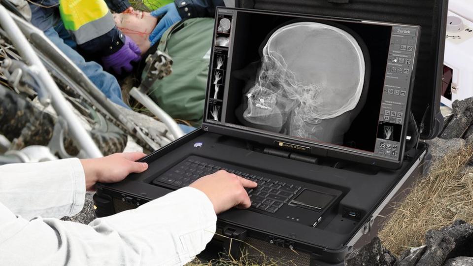Un trabajador de emergencia mira una radiografía en la carretera en una maqueta de capacitación.