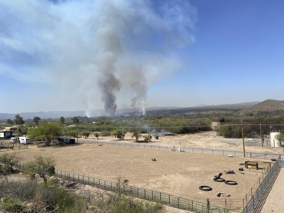 In this Friday, April 9, 2021. photo provided by Arizona Department of Forestry & Fire Management, the Pinal County Wildfire burns near rural properties in Dudleyville, Ariz. A small community in south-central Arizona remained under an evacuation notice Friday after crews and air tankers stopped the growth of a wildfire that burned at least 12 homes, officials said. (Arizona Department of Forestry & Fire Management via AP)