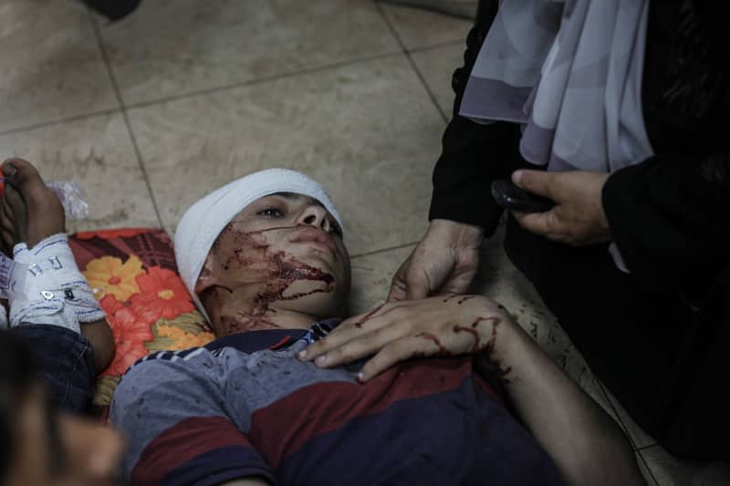 An injured Palestinian lies in a corridor at the Al-Aqsa Martyrs Hospital in Deir al-Balah in the central Gaza Strip, following Israel bombardment. Str/APA Images via ZUMA Press Wire/dpa