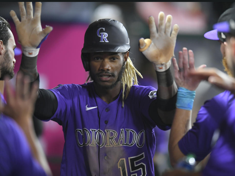 Colorado Rockies' Raimel Tapia is congratulated after scoring during the seventh inning of the team's baseball game against the Los Angeles Angels on Wednesday, July 28, 2021, in Anaheim, Calif. (AP Photo/John McCoy)